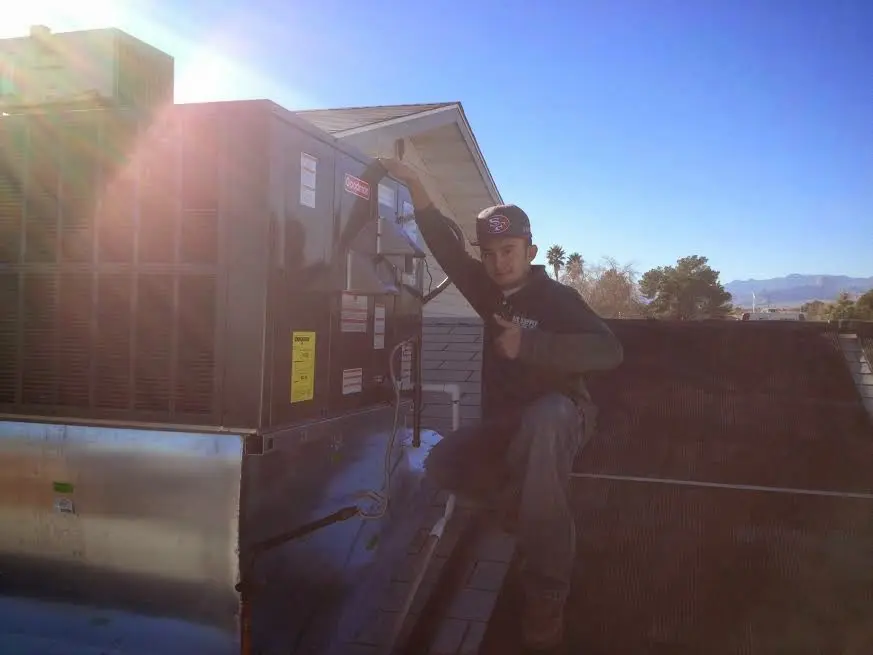 HVAC technician performing HVAC Inspection on a rooftop unit in Orange